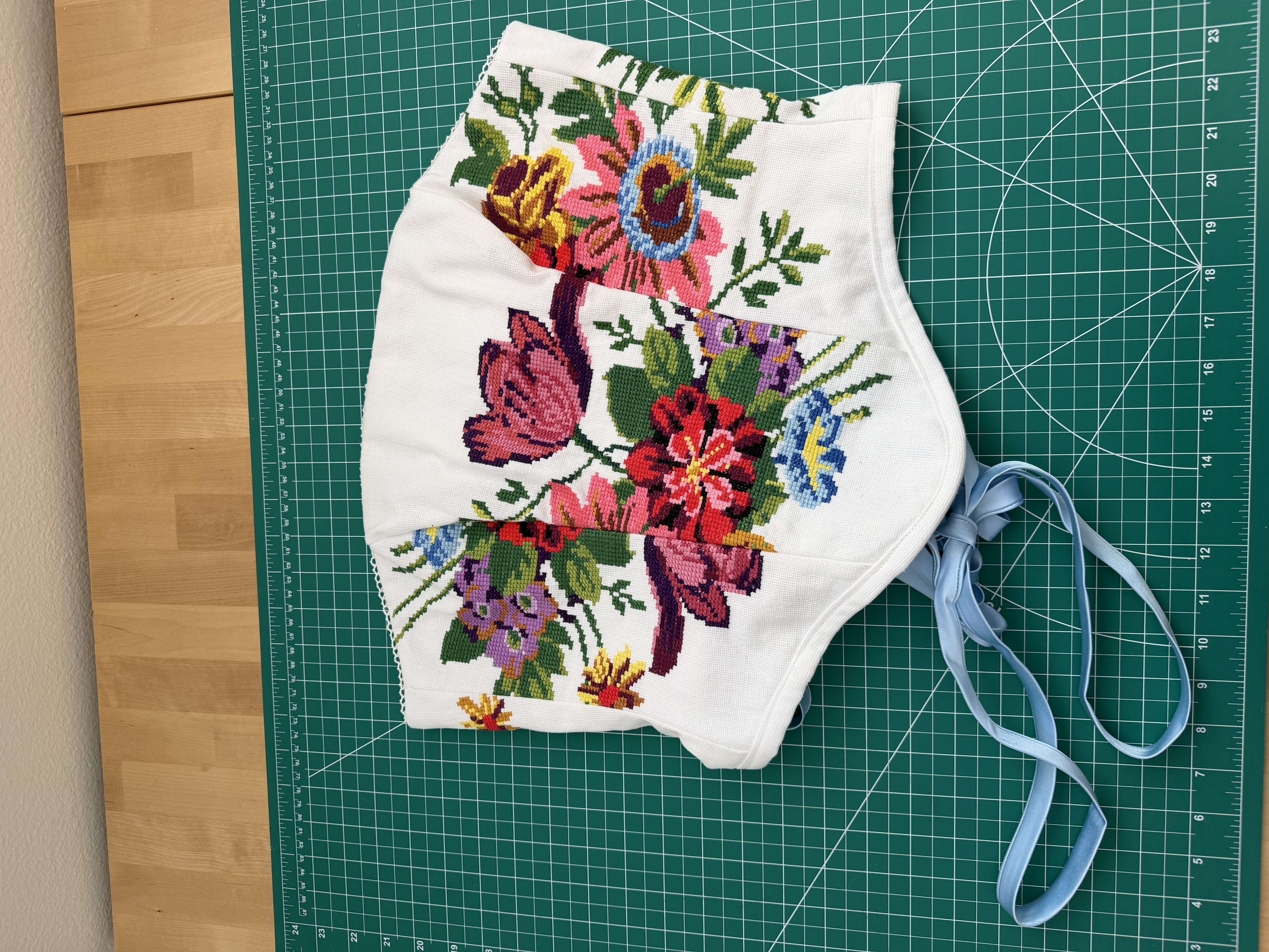 The finished corset laid flat on the cutting mat, front view